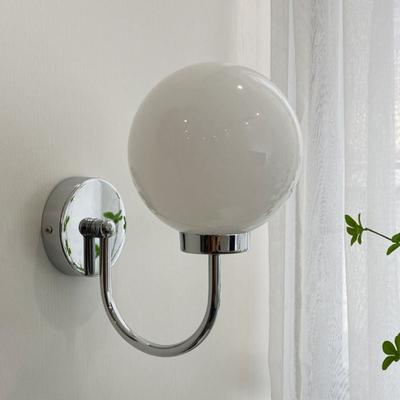 Celestial Orb Wall Lamp showcasing its elegant swoop-style arm and glossed glass lampshade in a modern setting.