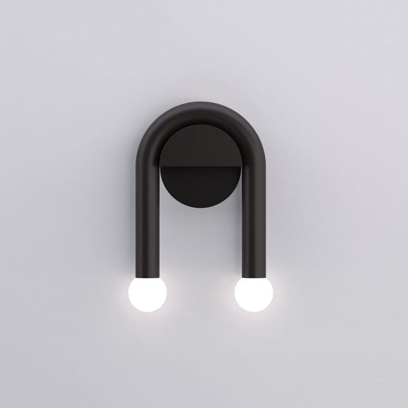 ArchLite Dual-Glow Wall Sconce elegantly lighting up a modern living room, showcasing its unique arched design.