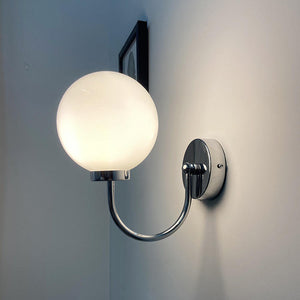 Celestial Orb Wall Lamp showcasing its elegant swoop-style arm and glossed glass lampshade in a modern setting.