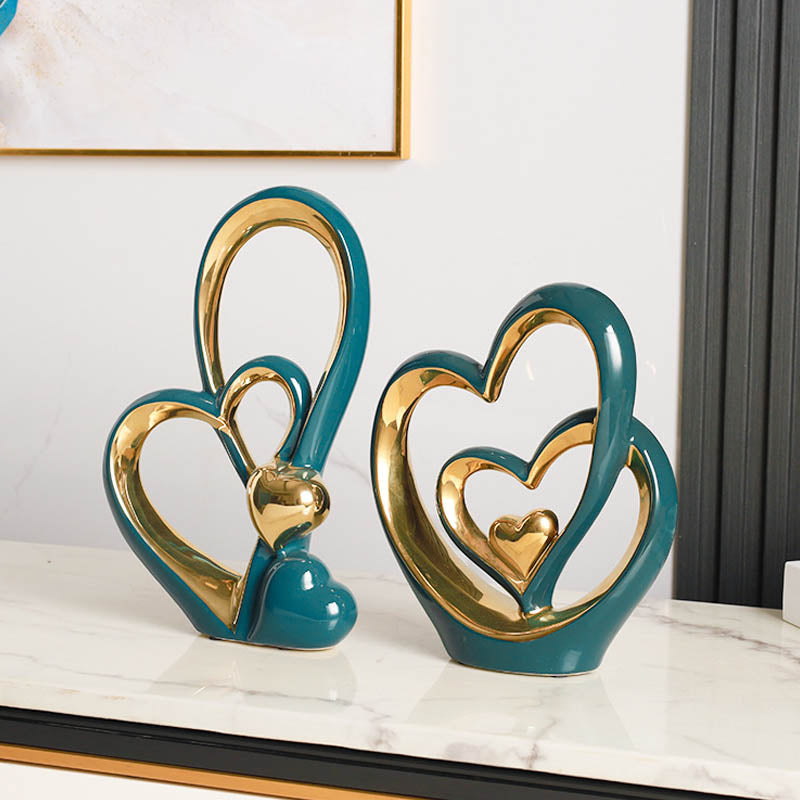 Golden Heart Intertwined Love Sculpture in glossy teal ceramic with gold details, a modern and luxurious decor accent for any space.