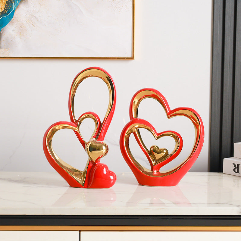Golden Heart Intertwined Love Sculpture in vibrant red ceramic with gold accents, showcasing intertwined hearts for romantic and contemporary decor.