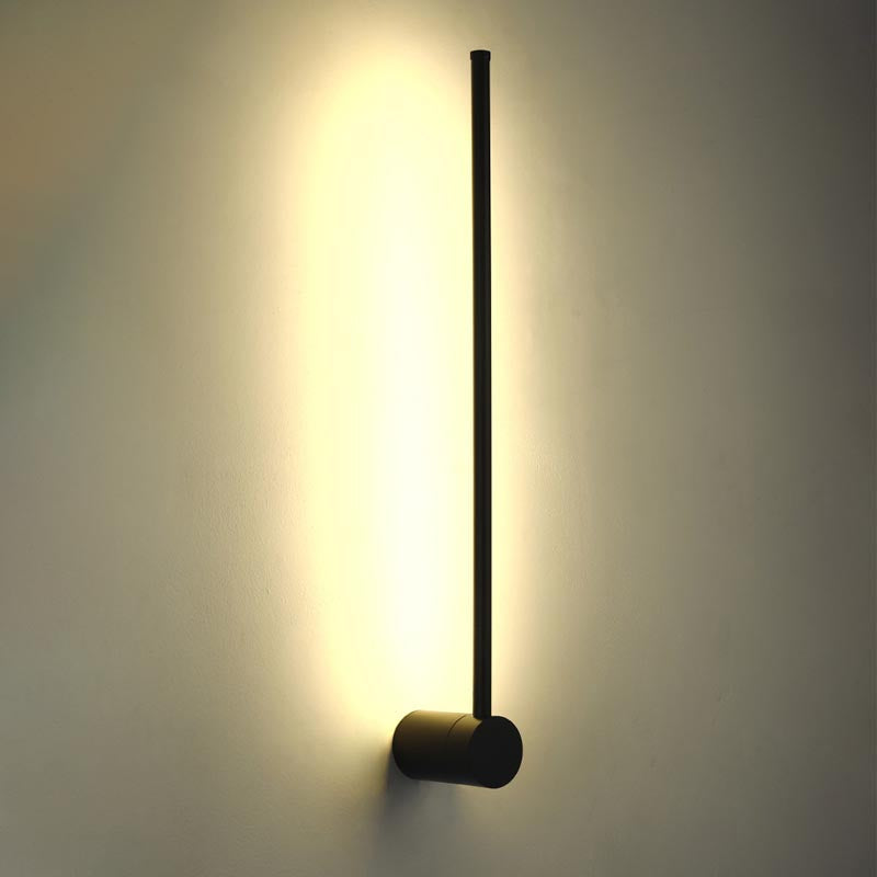 SleekLine LED Illuminator elegantly hung vertically in a modern living room, emitting a warm glow.