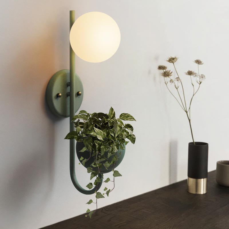 Verena Botanic Wall Lamp with an integrated plant holder in a cozy living room setting.