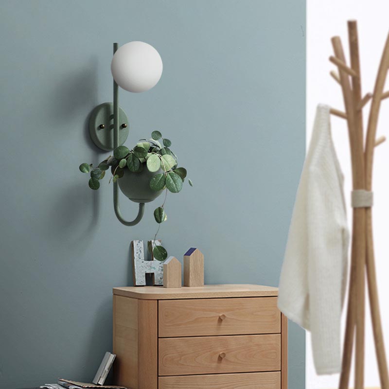 Verena Botanic Wall Lamp with an integrated plant holder in a cozy living room setting.