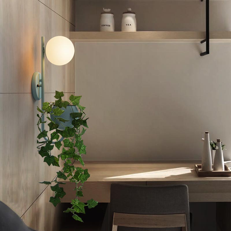 Verena Botanic Wall Lamp with an integrated plant holder in a cozy living room setting.