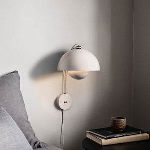 Blooming Grace Wall Lamp casting a warm glow in a stylish living room, highlighting its unique flower bud-inspired design and premium materials.