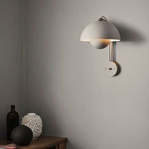 Blooming Grace Wall Lamp casting a warm glow in a stylish living room, highlighting its unique flower bud-inspired design and premium materials.