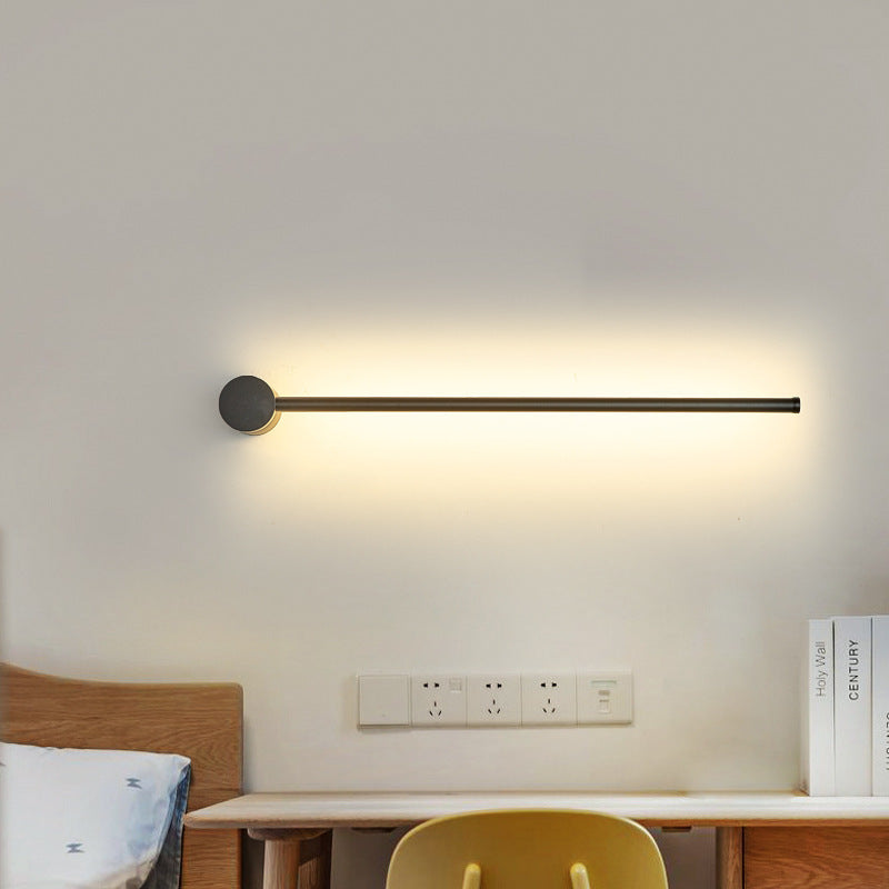 SleekLine LED Illuminator elegantly hung vertically in a modern living room, emitting a warm glow.