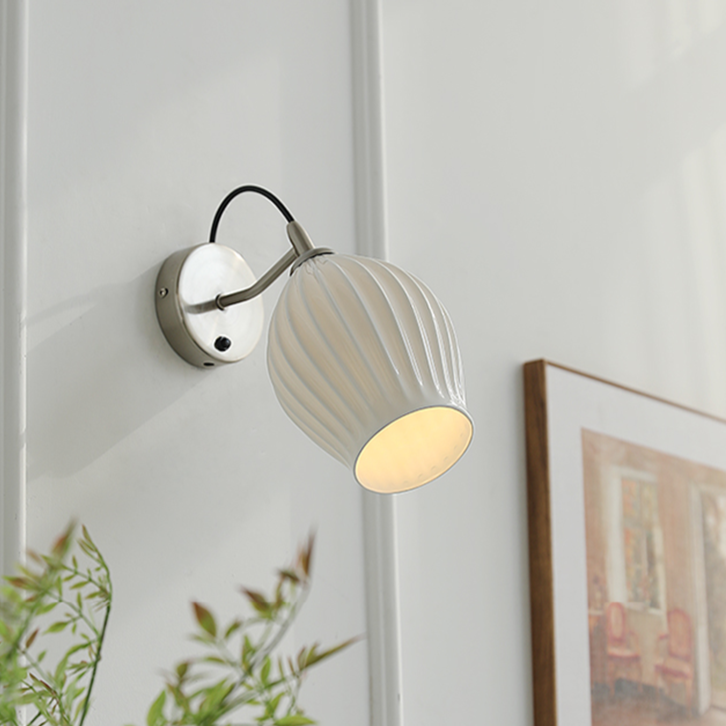 Celestia Pleated Ceramic Wall Sconce with a pleated ceramic lampshade and Chrome or Brass base, ideal for adding a touch of sophistication to any room.