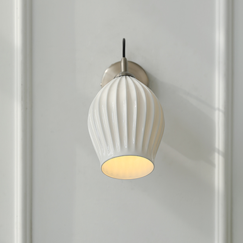Celestia Pleated Ceramic Wall Sconce with a pleated ceramic lampshade and Chrome or Brass base, ideal for adding a touch of sophistication to any room.