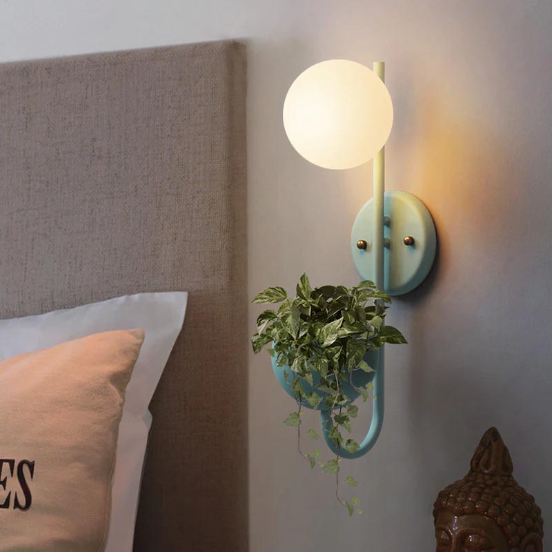 Verena Botanic Wall Lamp with an integrated plant holder in a cozy living room setting.