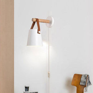 Rustic Elegance Belted Wall Lamp illuminating a cozy reading nook, showcasing its unique blend of metal, wood, and leather.