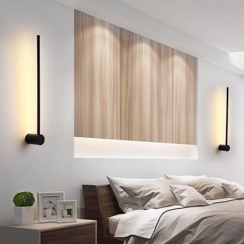 SleekLine LED Illuminator elegantly hung vertically in a modern living room, emitting a warm glow.