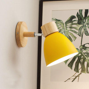 Vibrant Rotating Sconce in a cozy bedroom setting, showcasing its colorful finish.